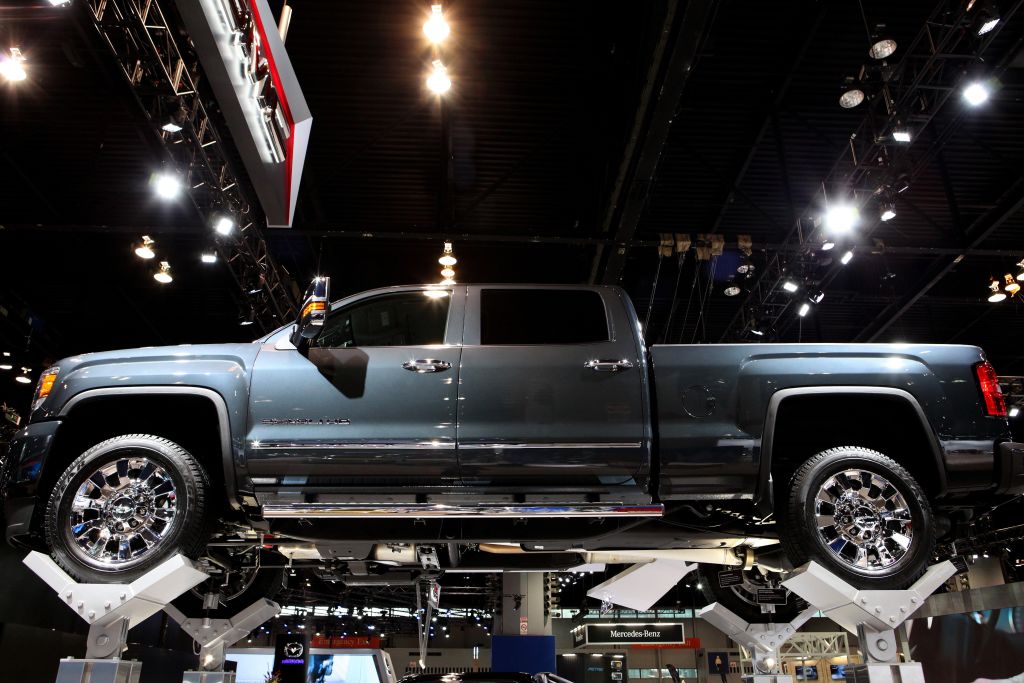 A new GMC Sierra Denali displayed on a lift at an auto show