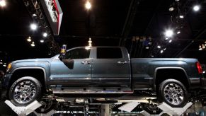 A new GMC Sierra Denali displayed on a lift at an auto show