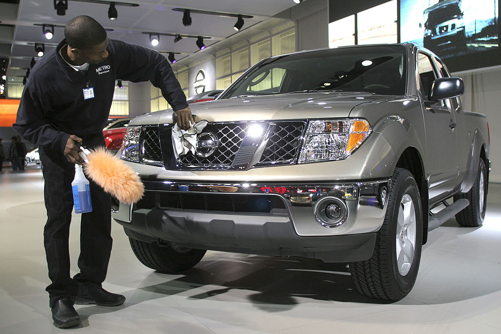 A man polishes the front of a Nissan Frontier