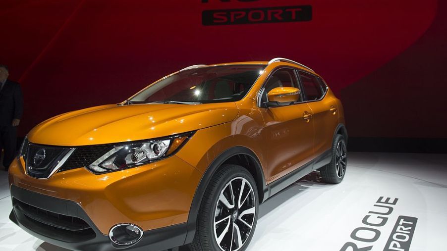 An orange Nissan Rogue Sport on display at an auto show