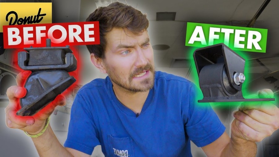 Man holds worn-out and brand-new engine mounts