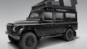 Black carbon-fiber RTC 110 roof tent mounted on black classic Land Rover Defender 110