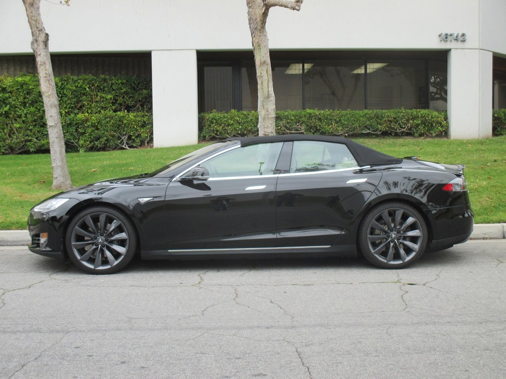 A black Tesla Model S with its convertible top up