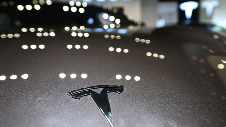 A Tesla logo is seen on a vehicle at a Tesla store