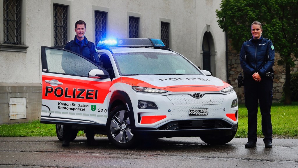 Police officers stand by a Hyundai Kona Electric that has police livery