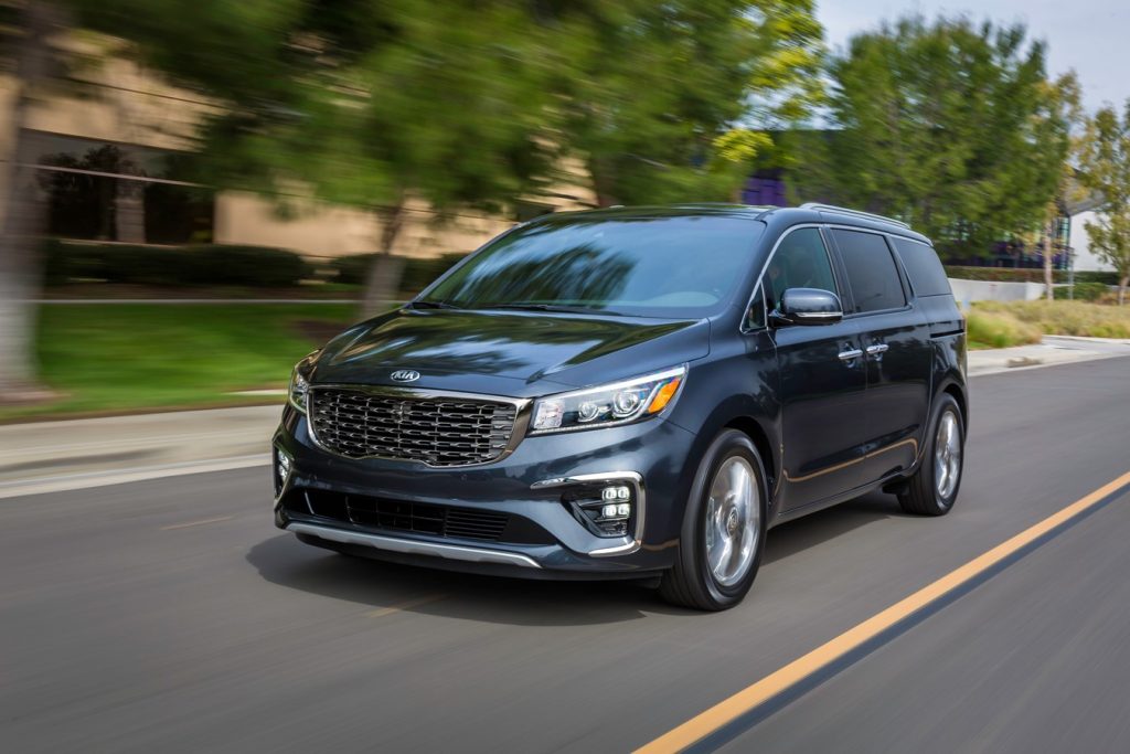the Kia Sedona parked in an urban area in front of a manmade body of water