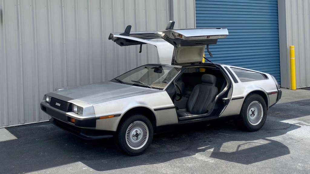 Stainless-steel 1981 DeLorean DMC-12 parked with the doors up