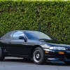 Black 1994 Nissan Silvia coupe in front of a hedge