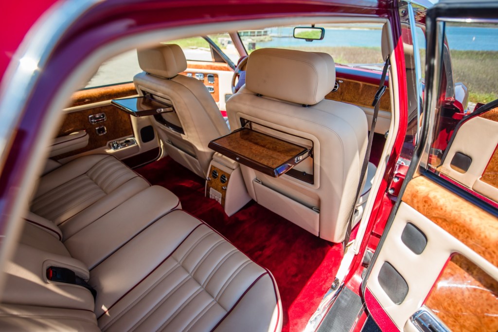 Tan leather and wood-trimmed interior of a red 1996 Rolls-Royce Silver Spur
