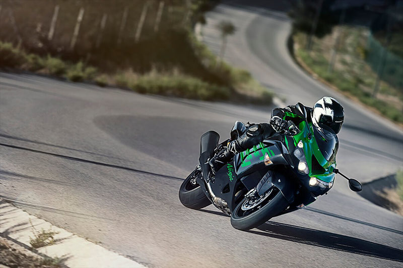 a bright green Kawasaki ninja zx-14r speeding through a winding turn