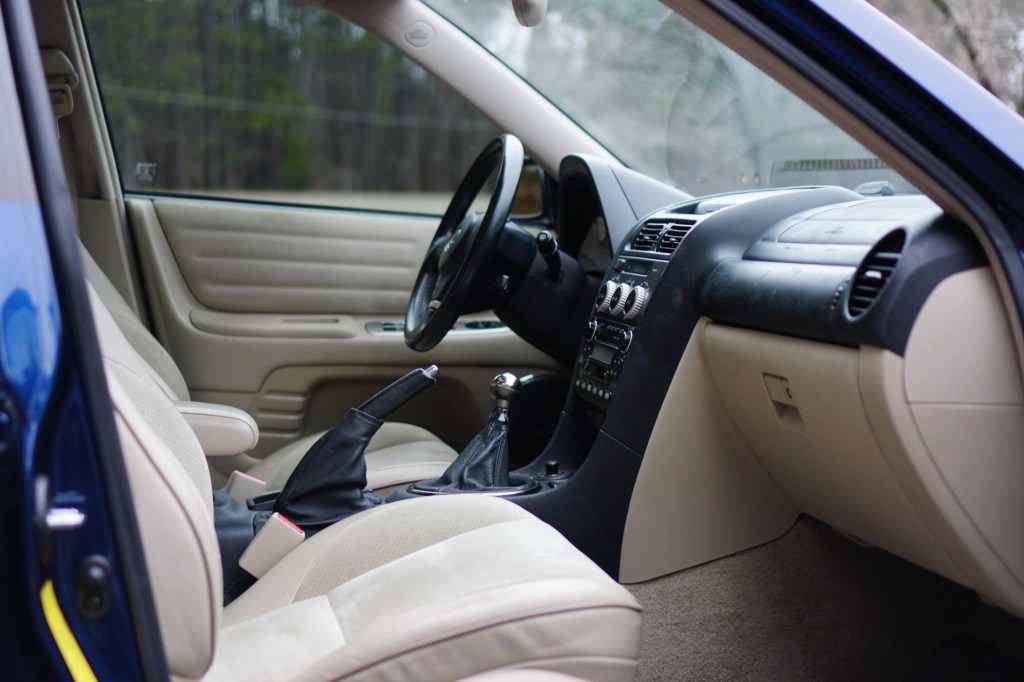 The tan leather front seats and black dashboard of a 2002 Lexus IS300