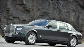 Gray 2003 Rolls-Royce Phantom VII side view, in front of a rocky cliff