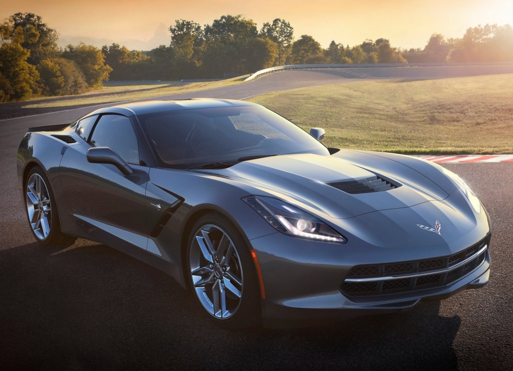 Gray 2014 C7 Chevrolet Corvette Stingray parked on a racetrack in front of a rising sun