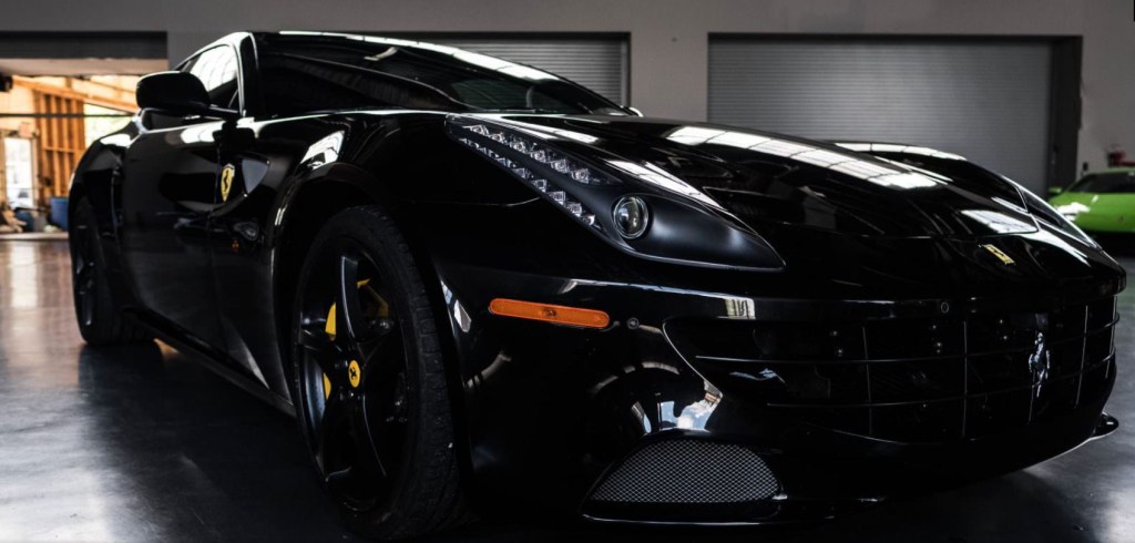 A knee-high view of the front of a black Ferrari FF