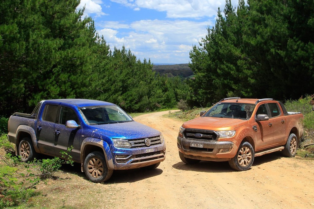 The Volkwagen Amarok and Ford Ranger are side by side on a dirt road