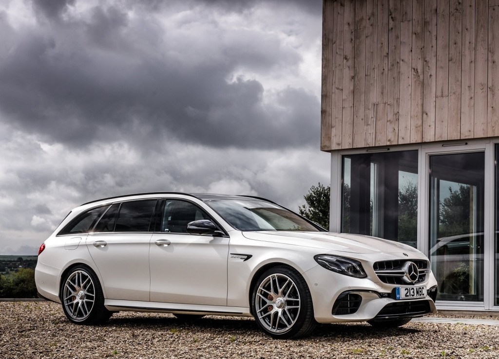White 2018 Mercedes-AMG E63 S Wagon parked in front of a modernist house