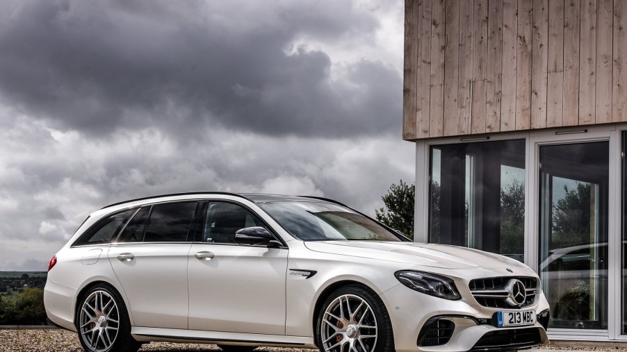 White 2018 Mercedes-AMG E63 S Wagon parked in front of a modernist house