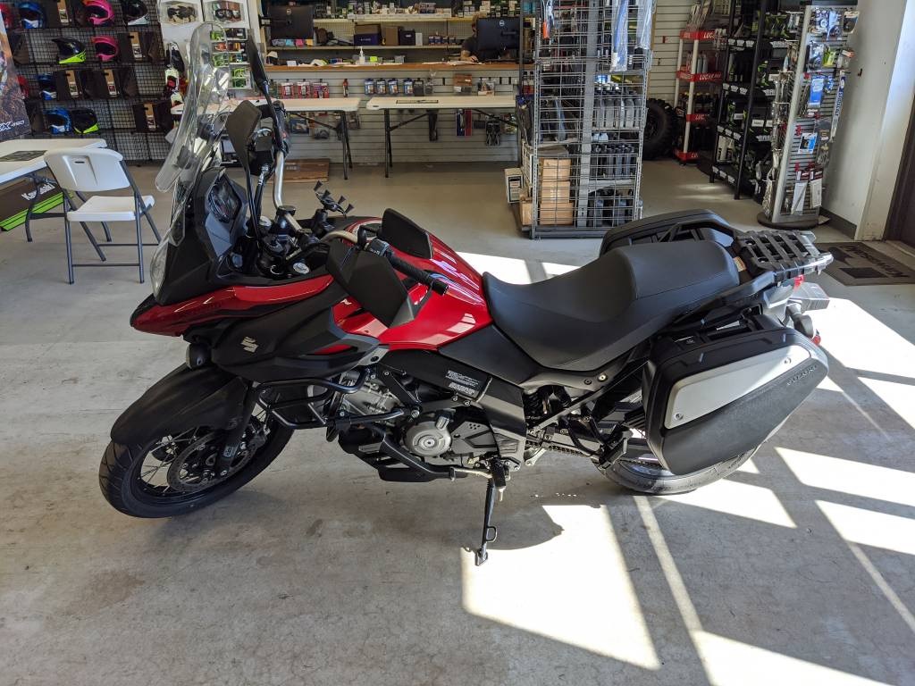 Red 2019 Suzuki V-Strom 650XT with saddle bags in a shop