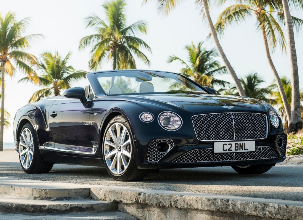 Black 2020 Bentley Continental GT V8 Convertible in front of palm trees with the roof down