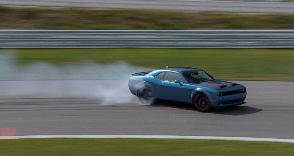 A blue 2020 Dodge Challenger drifts at the track