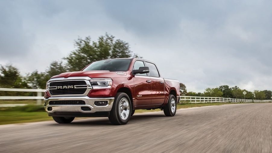a new red Ram 1500 pickup truck driving through some farm land