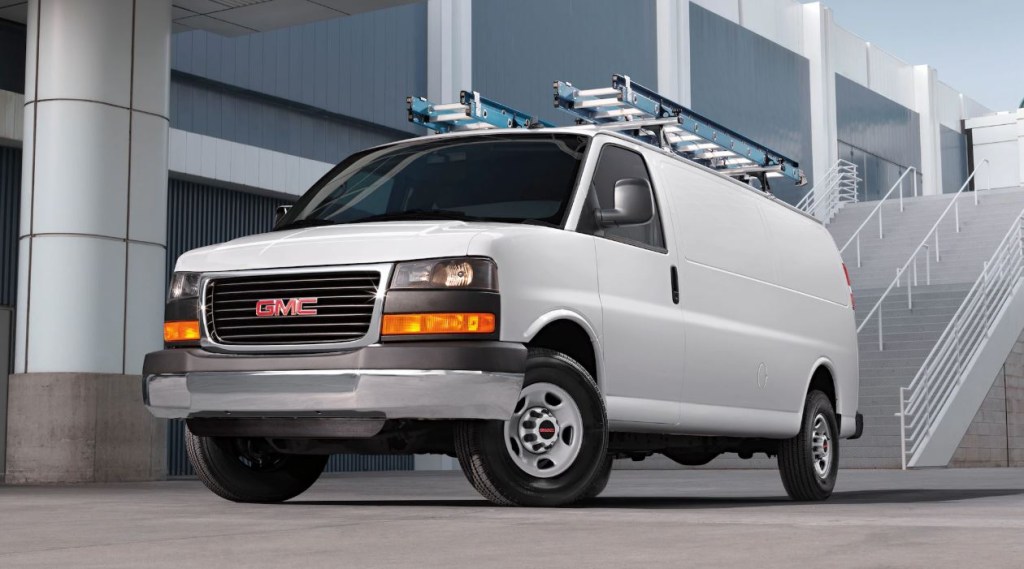 A white 2020 GMC Savana cargo van sits in front of a large commercial building