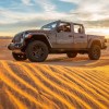 Grey-brown 2020 Jeep Gladiator Mojave truck crossing a dune at sunset