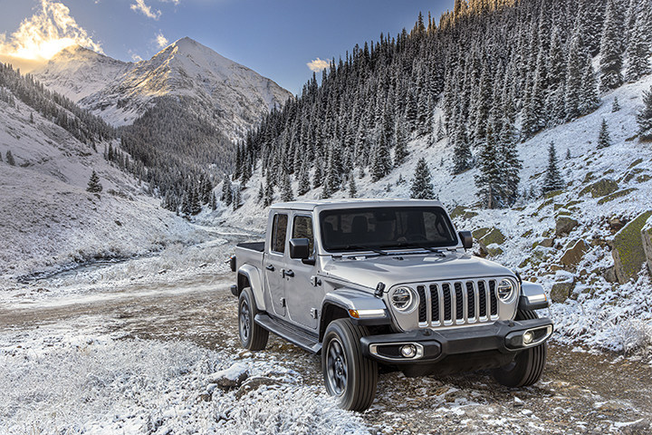 A Jeep Gladiator at the base of a snow covered mountain