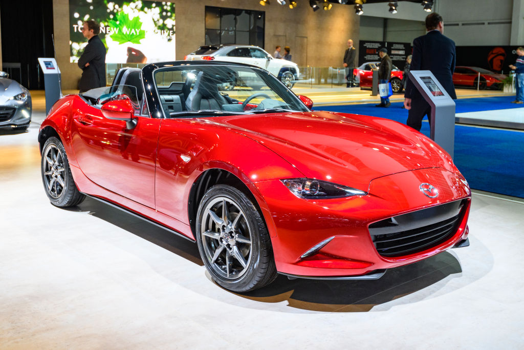 A red Mazda Miata on display at an auto show