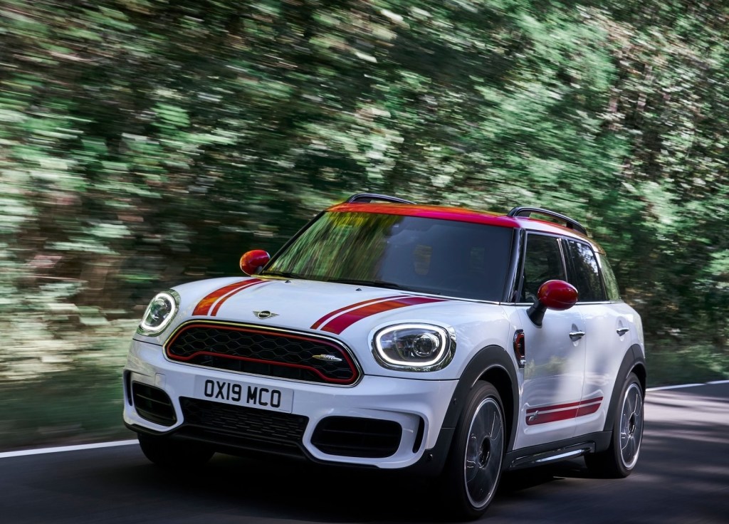 White-and-red-striped 2020 Mini Countryman John Cooper Works driving through a forest