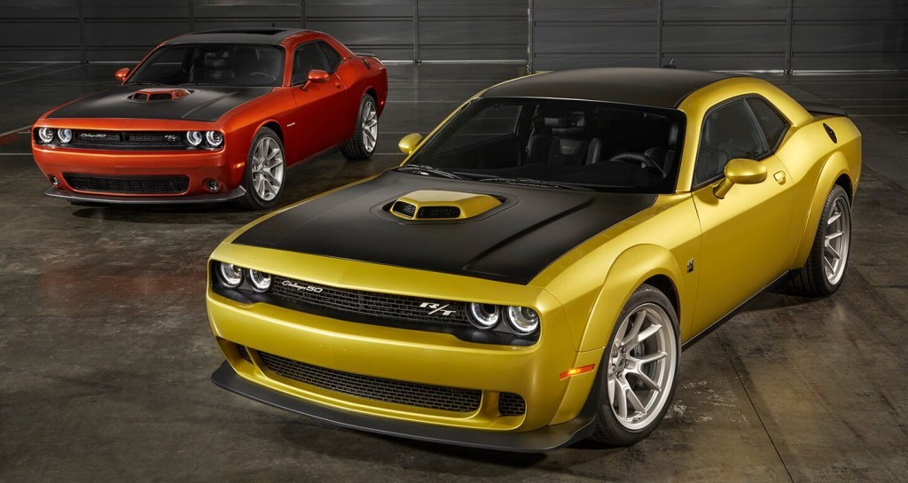 A red and Yellow 2020 Dodge Challenger are beside each other in a garage.