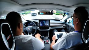 driver and passenger with all hands off of controls of car in autonomous driving experiment