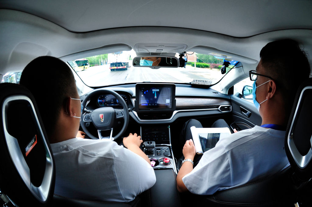 driver and passenger with all hands off of controls of car in autonomous driving experiment