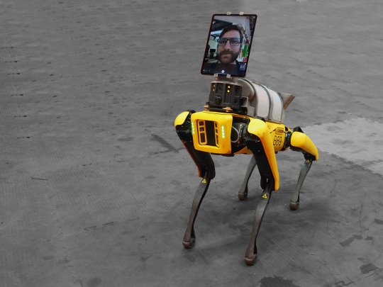 yellow robor dog with video image of person's head