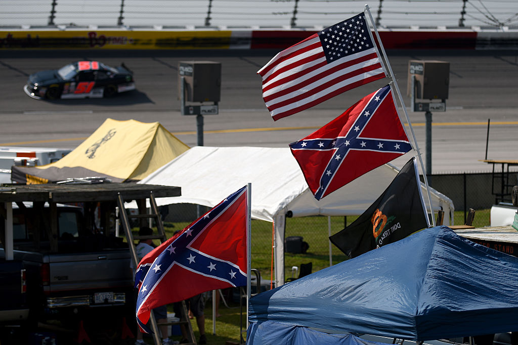 Confederate flags flying with American flags inside of NASCAR track