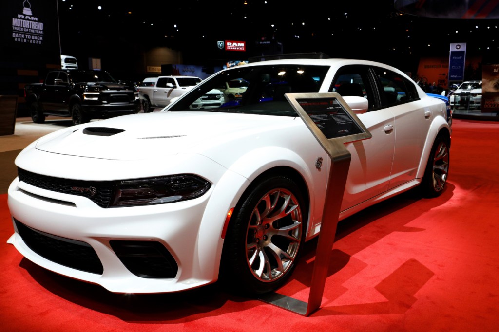 A white Dodge Charger on display at an auto show