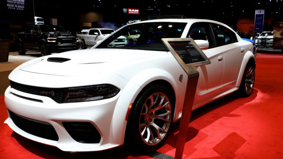 A white Dodge Charger on display at an auto show