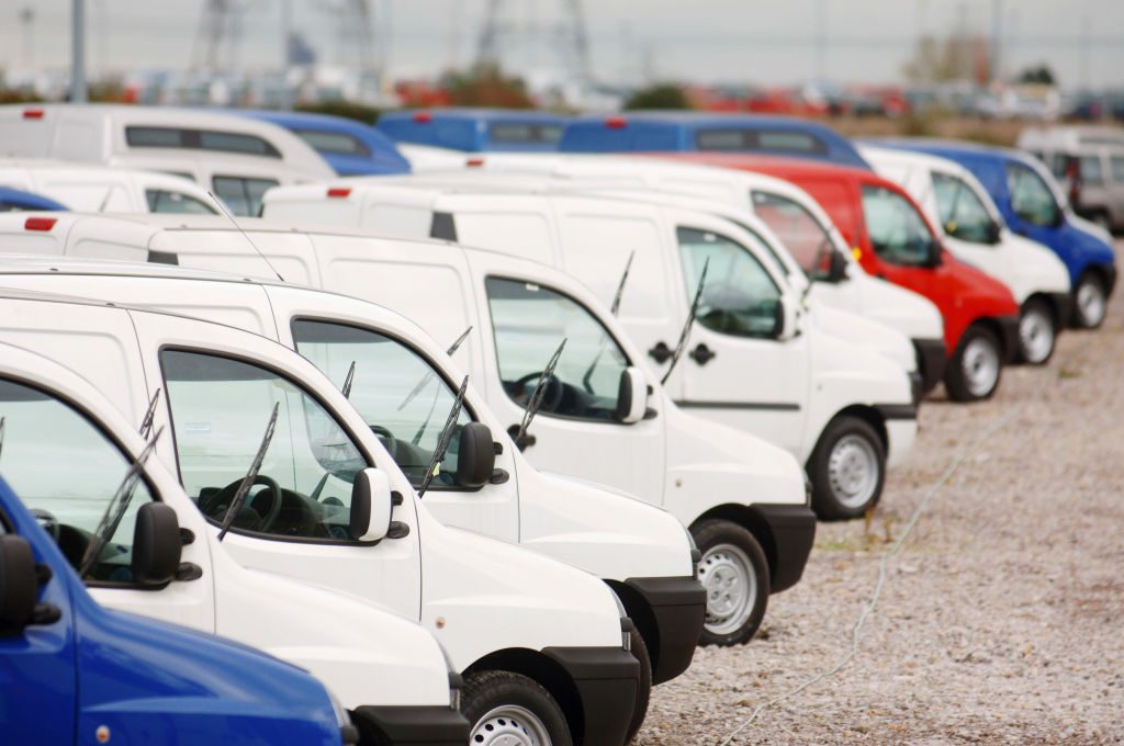 White Fiat cargo vans lined up for delivery in the UK in the 