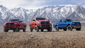 Red Level 2, orange Level 3, and blue Level 1 Ford Performance-modified Rangers in front of a mountain range