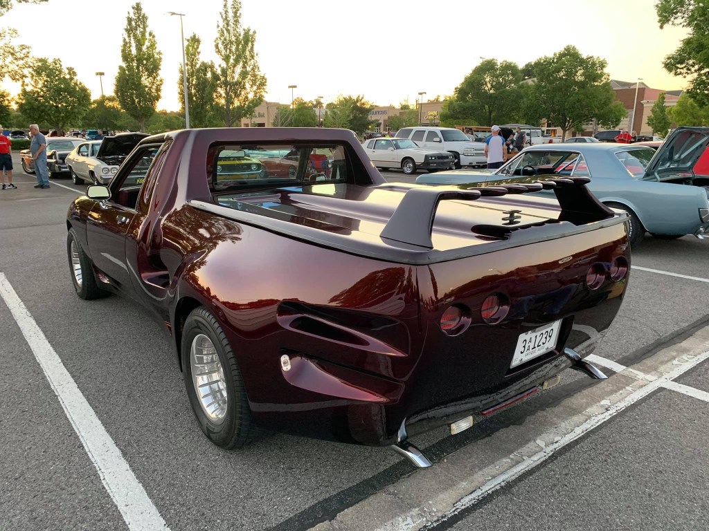 an 80s car turned into a pickup truck in a parking lot