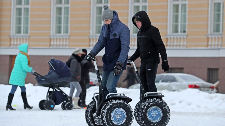 Young men ride Segway two-wheeled personal transporters
