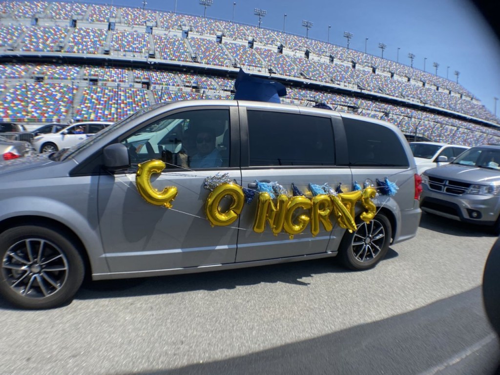 A minivan is decorated to honor a high school senior that is graduating at a ceremony at Daytona International Speedway