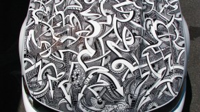 A white Mustang's hood is covered in marker art