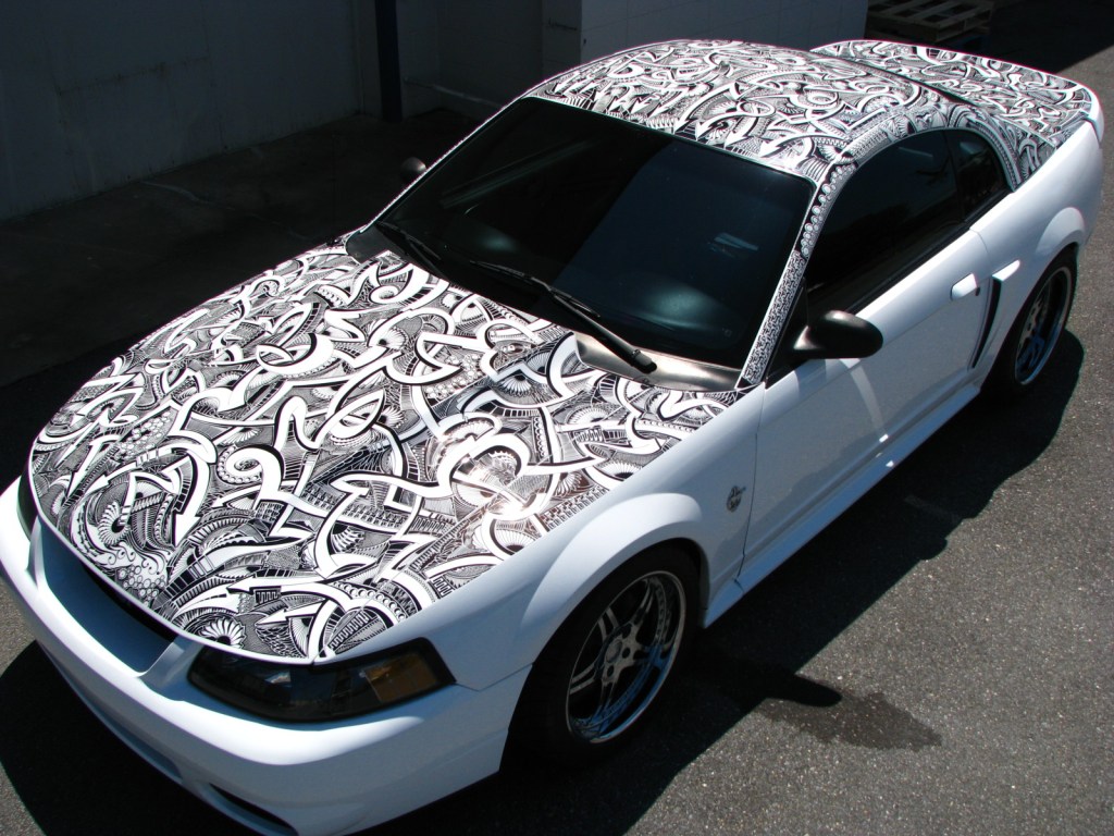 A white Ford Mustang has marker art on all the horizontal surfaces.
