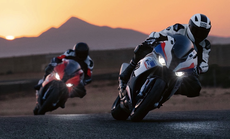two 1-liter BMW sportbikes opening up the throttle on a desert racetrack.