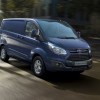 A new blue Ford Transit driving on the street