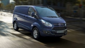 A new blue Ford Transit driving on the street
