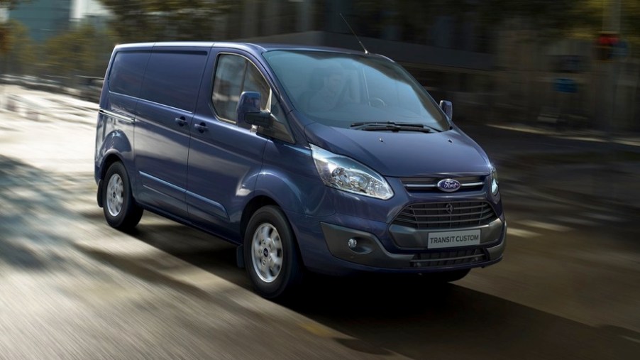 A new blue Ford Transit driving on the street