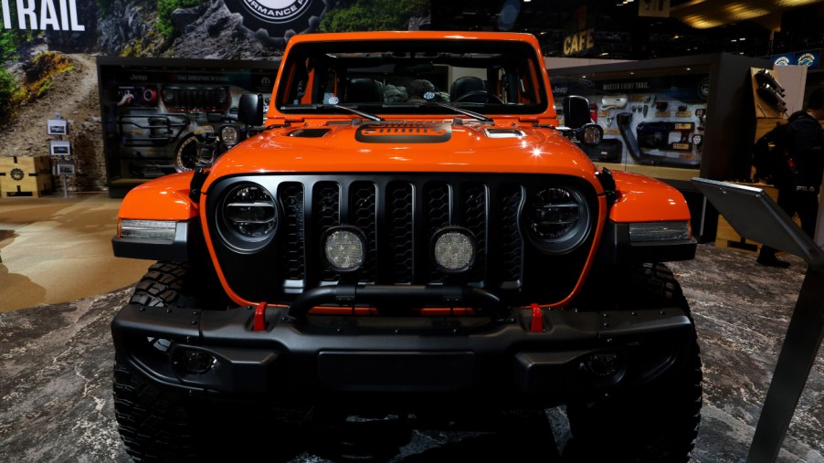 An orange Jeep Gladiator on display at an auto show