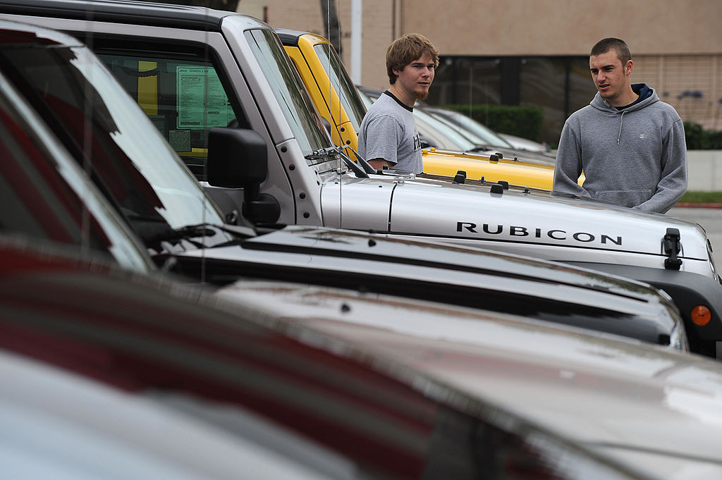 Car shoppers inspect a row of Jeep Wranglers